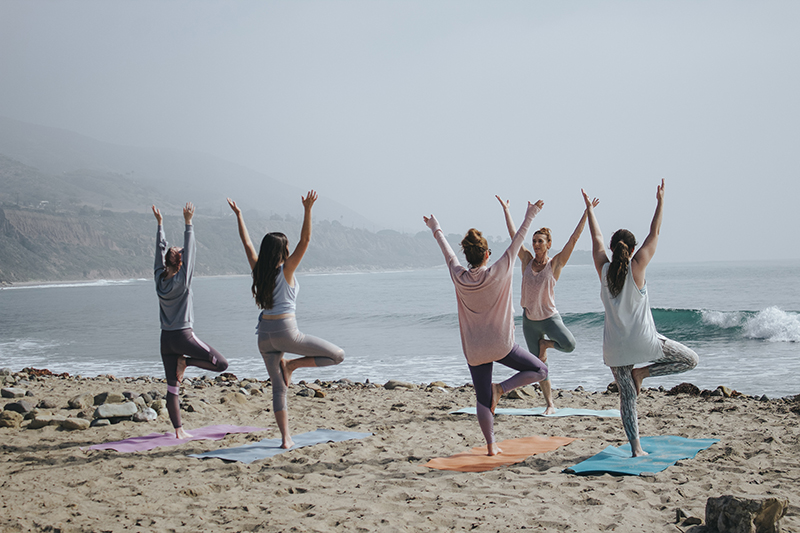Women doing yoga on a beach