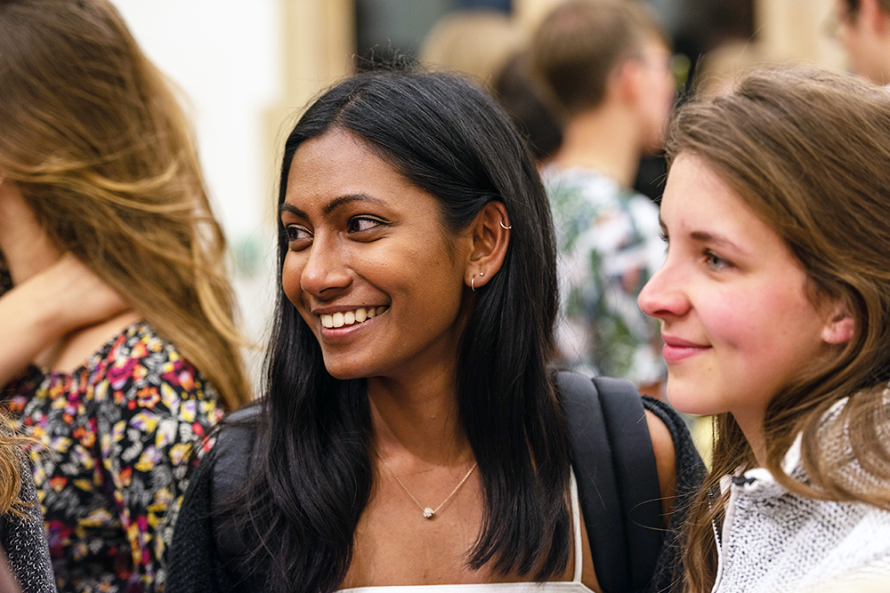Students smiling and talking at an event