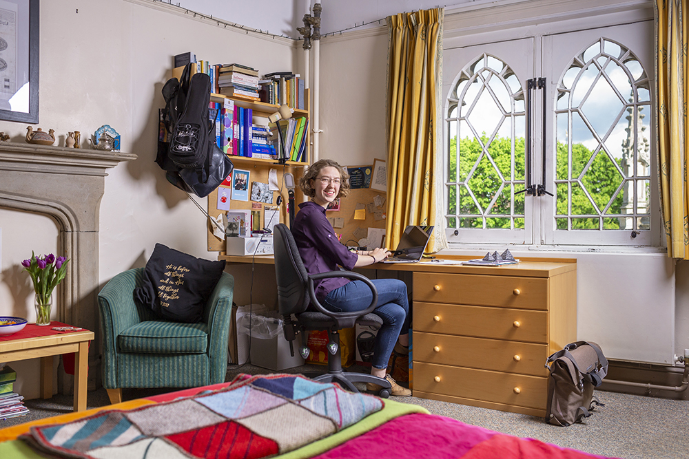 A student sits in her room at her desk